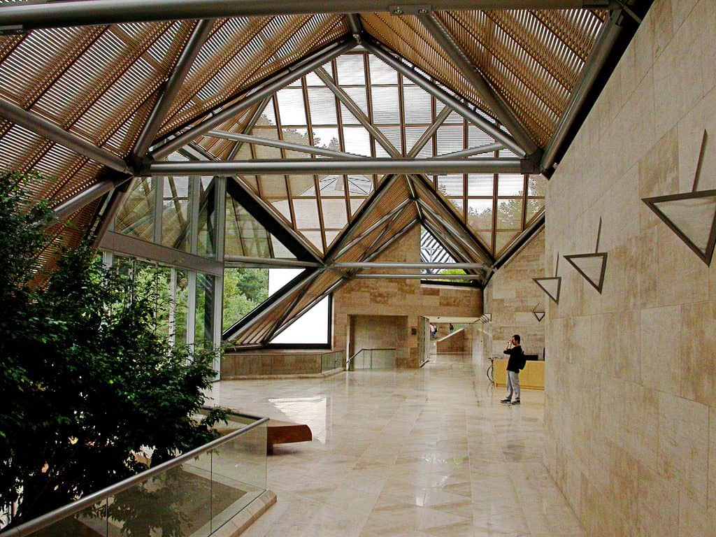 The interior of a contemporary Japanese museum with a soaring geometric timber and glass roof