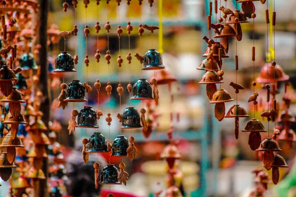 Rows of handmade ceramic wind chimes for sale at an outdoor craft market in Kyoto