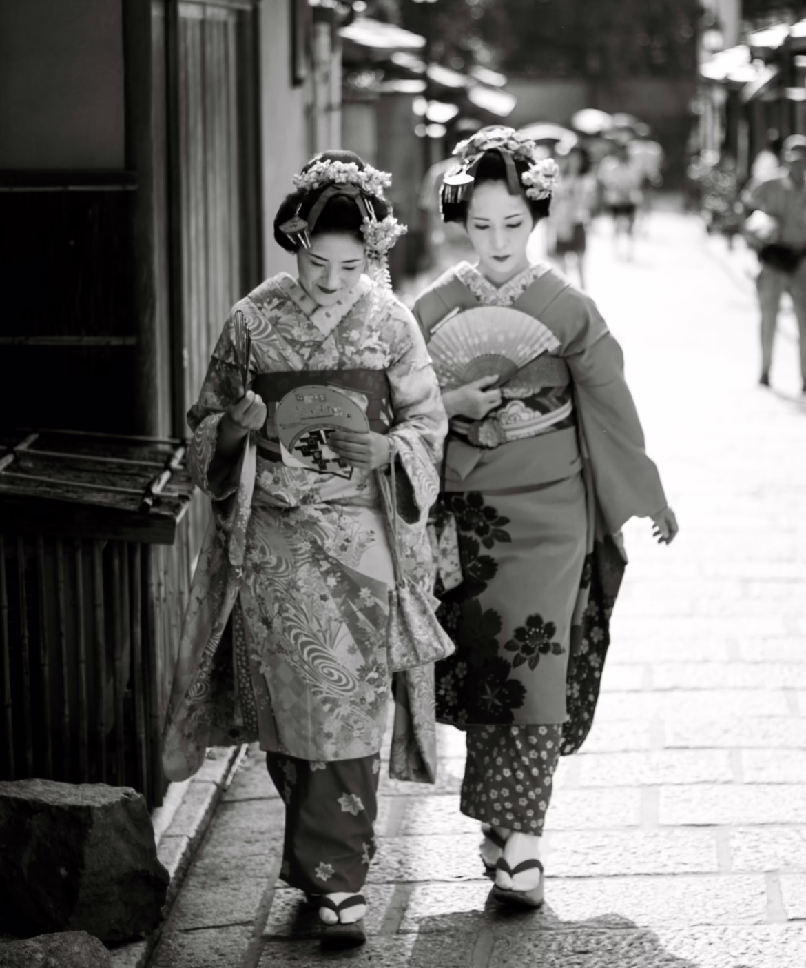 Two women dressed in traditional kimono walking in a historic Japanese street, representing Japan’s vintage fashion and cultural heritage.
