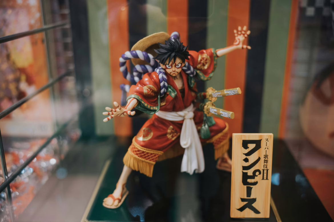 A detailed One Piece figurine of Monkey D. Luffy dressed in traditional Japanese Kabuki attire, featuring a red kimono, straw hat, and purple rope accents.