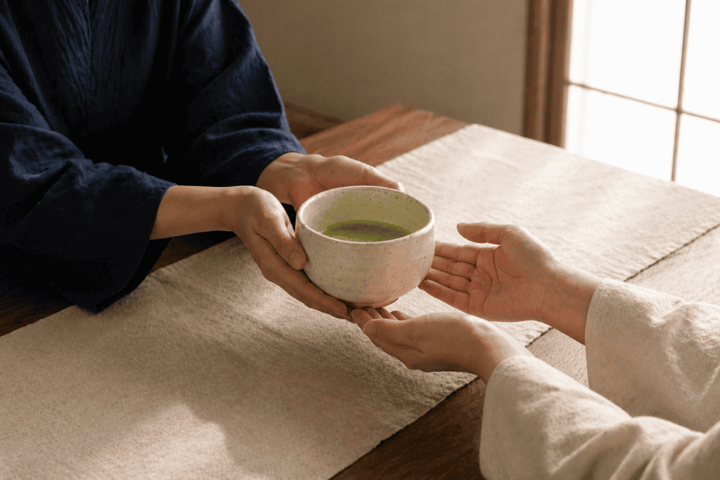 Two people passing a bowl of matcha during a Japanese tea ceremony