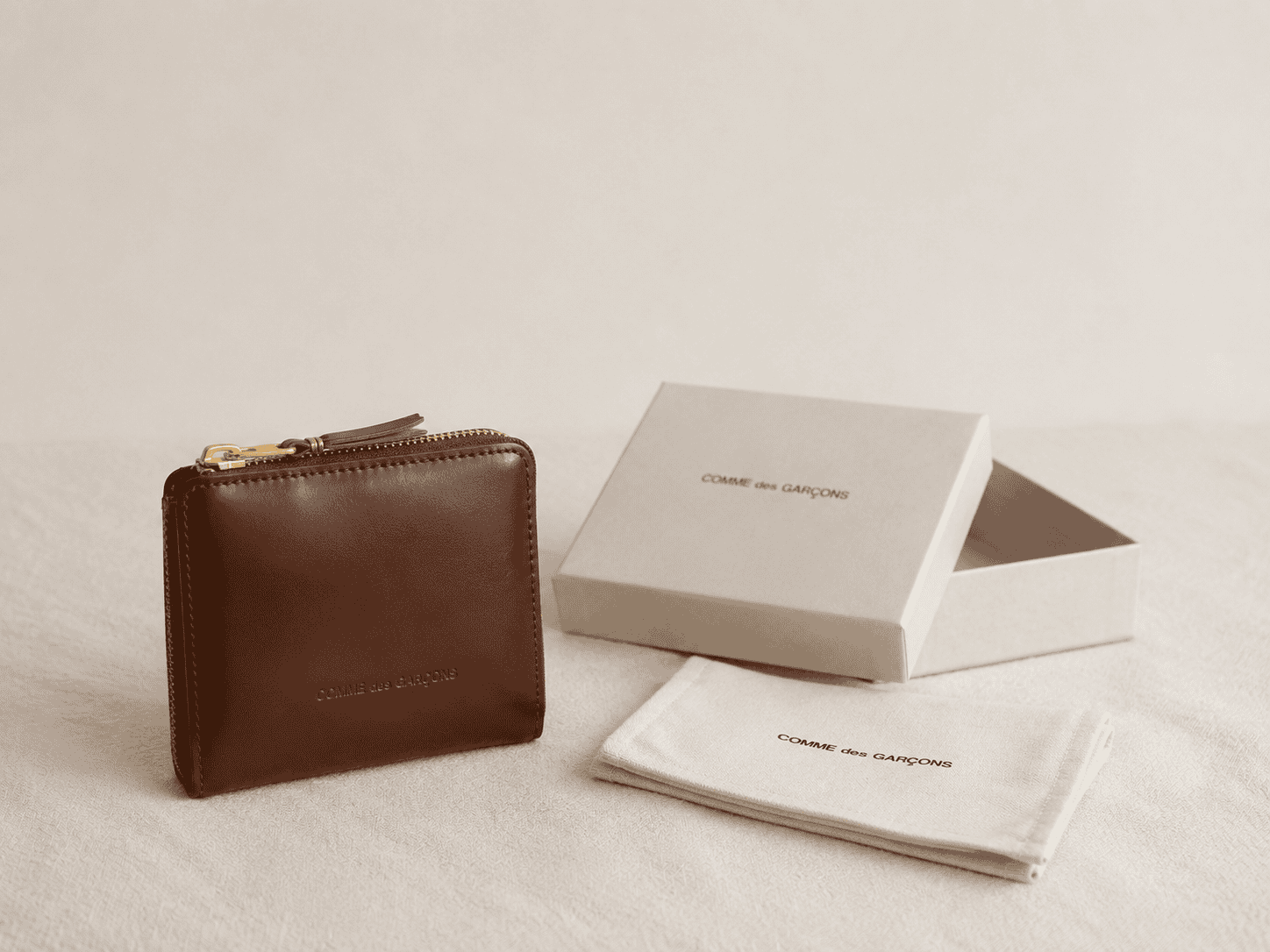 Brown Comme des Garçons leather wallet with a zip closure