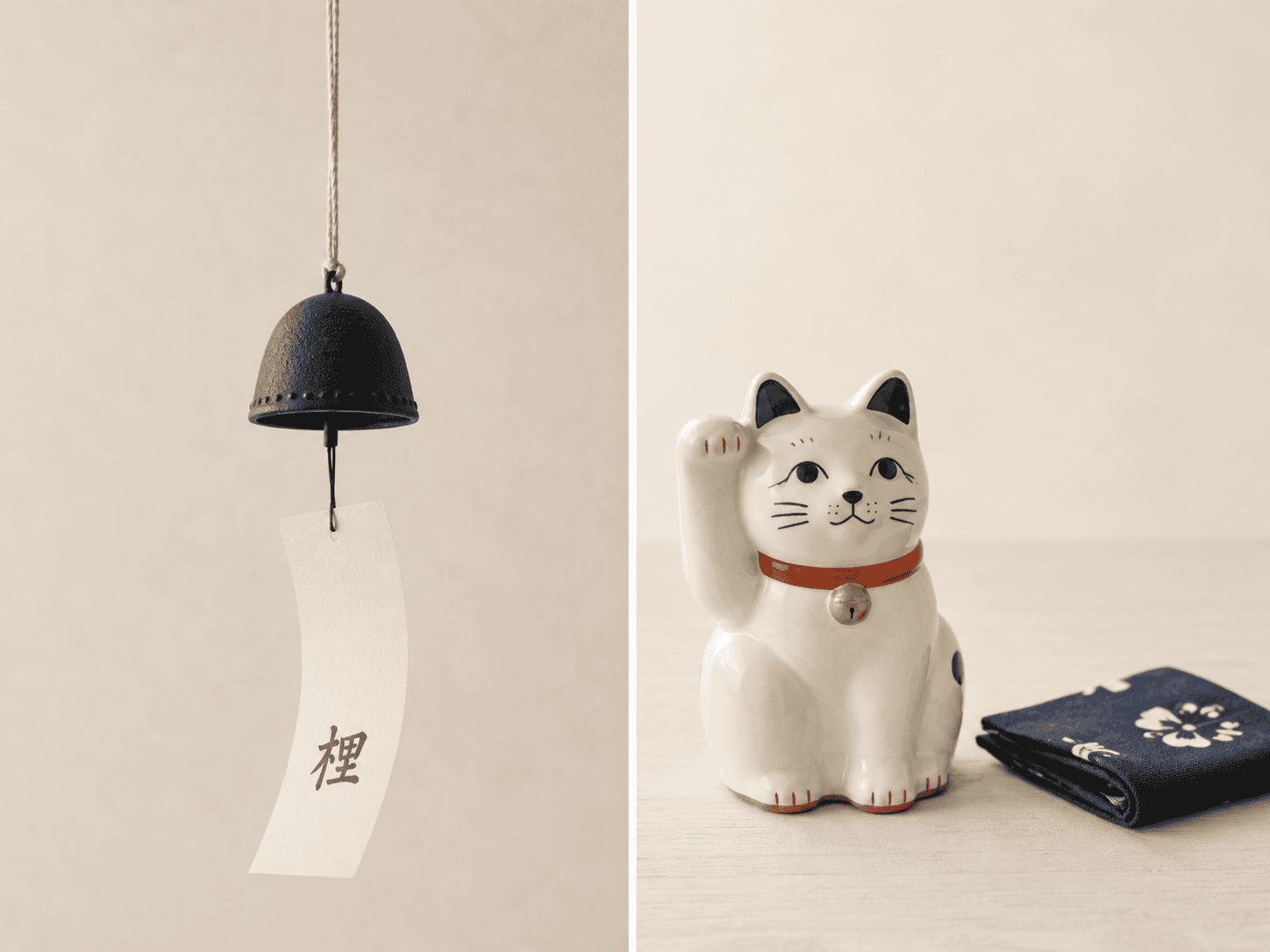 A white beckoning cat figurine beside a cast-iron wind chime and a folded indigo cloth
