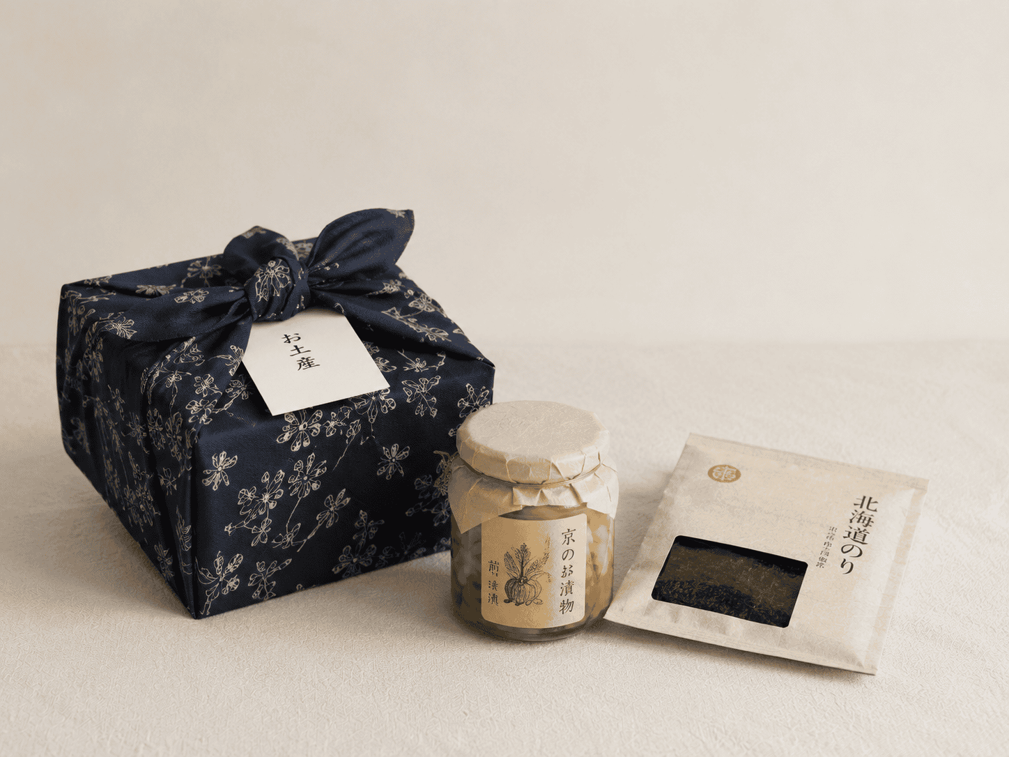 A wrapped Japanese gift set with a cloth-tied box, a jar and a paper packet