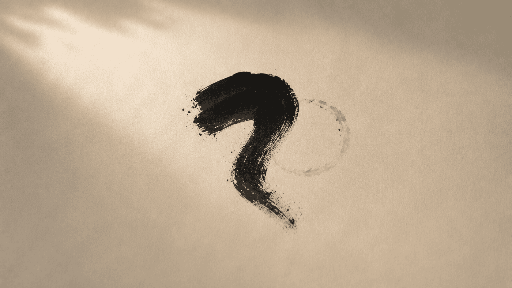 A single bold abstract ink character form drying at the centre of a large sheet of cream paper, surrounded by generous empty space