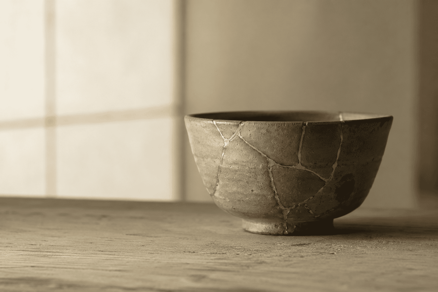 Japanese ceramic bowl with gold crackle glaze on wooden surface