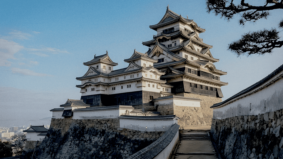 Himeji Castle's white keep above stone walls under a clear sky