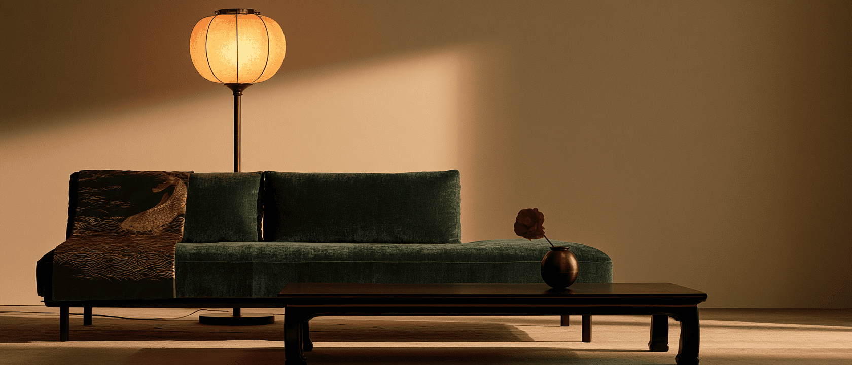 A green velvet sofa with a Japanese lantern lamp in a serene living room