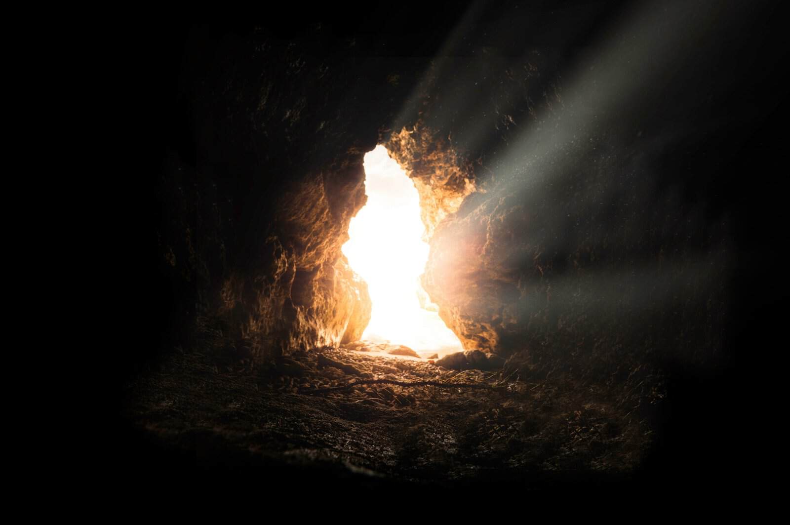 Sunlight streaming through a narrow gap in a dark cave, finding hope again when the light is small