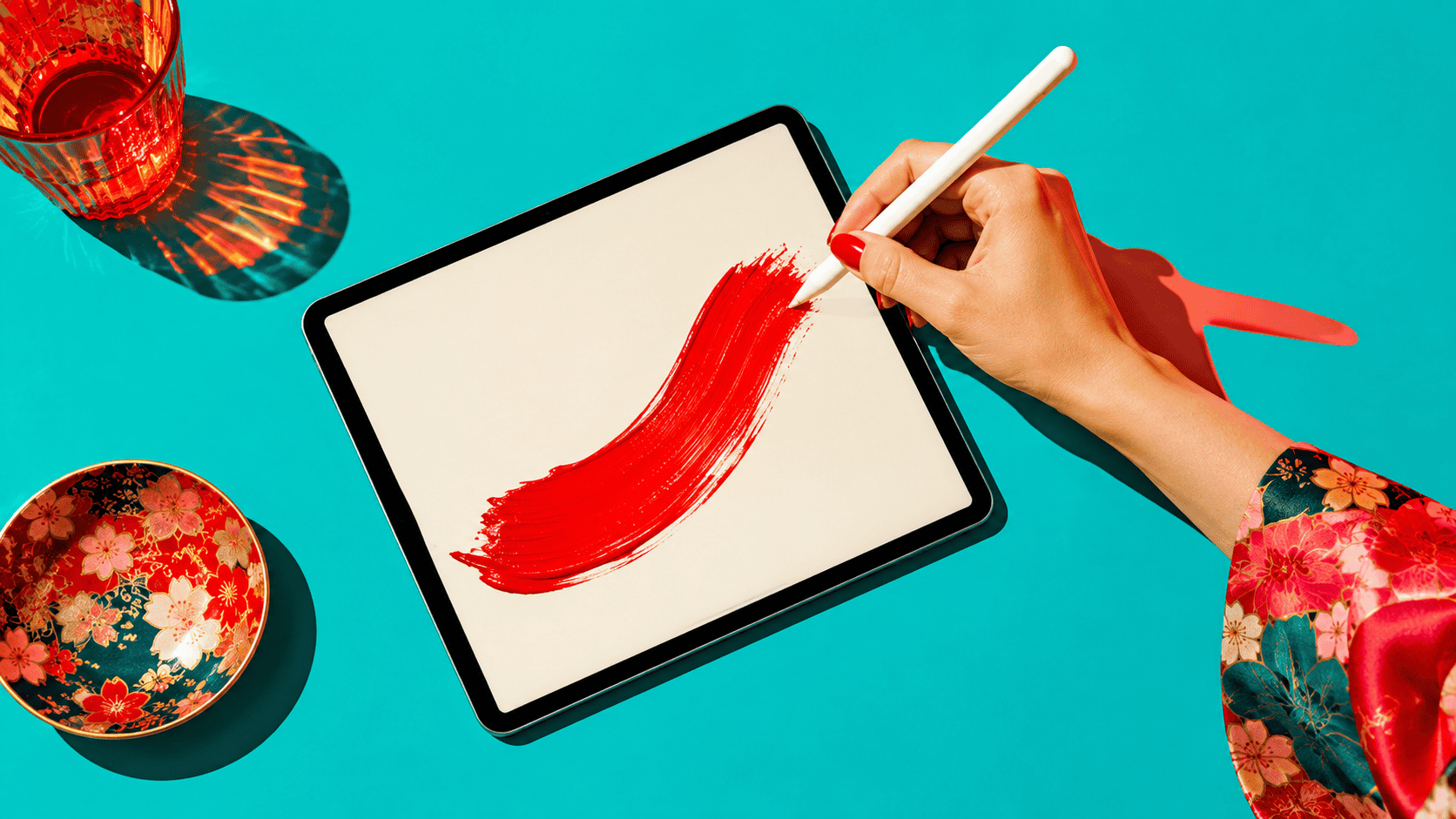 How to practice kanji on iPad: a hand with a stylus laying one bold red brushstroke across a tablet