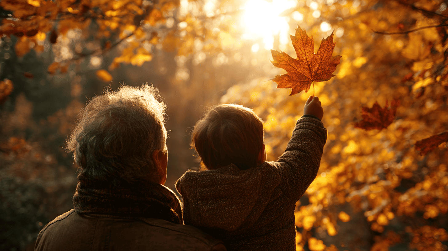 A child and a grandparent holding a red maple leaf up to the autumn light