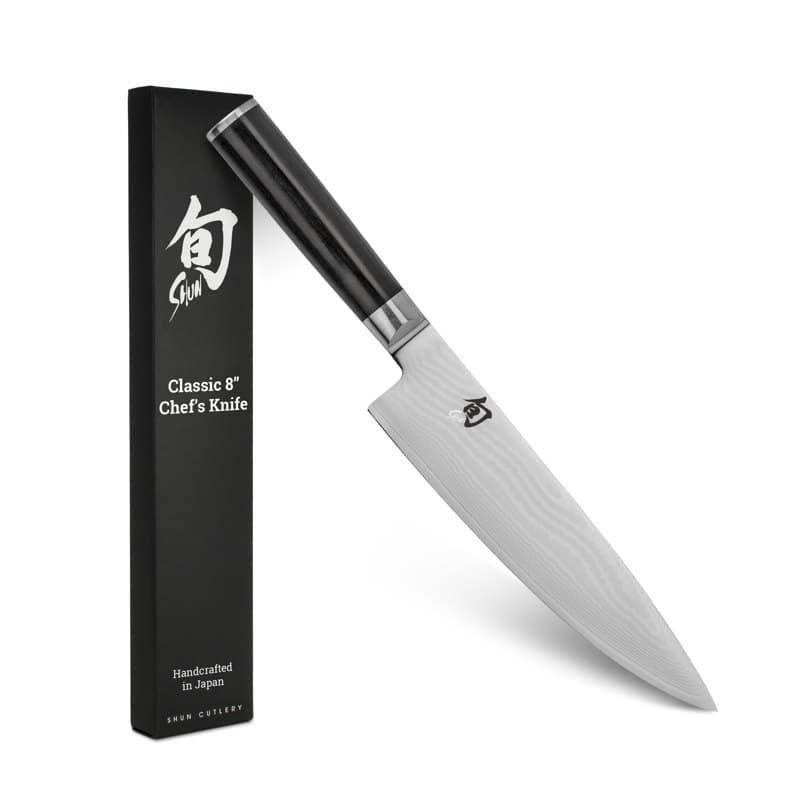 A Shun Classic 8-inch chef's knife with a Damascus-pattern blade and a dark pakkawood handle