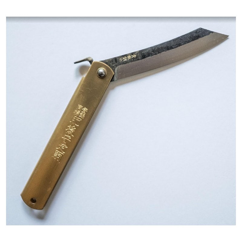 A Higonokami folding knife with a brass handle and a blue paper steel blade