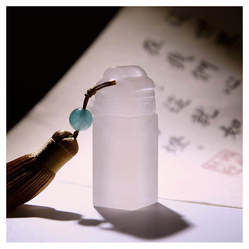 A white stone Japanese name seal with a tassel, custom carved with a name