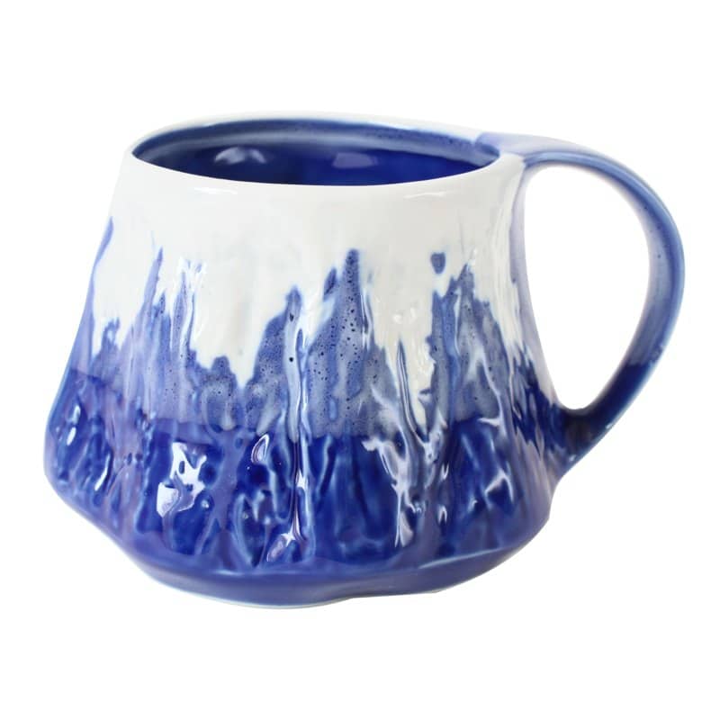 A blue and white Mino ware mug shaped like Mount Fuji with a snowy rim