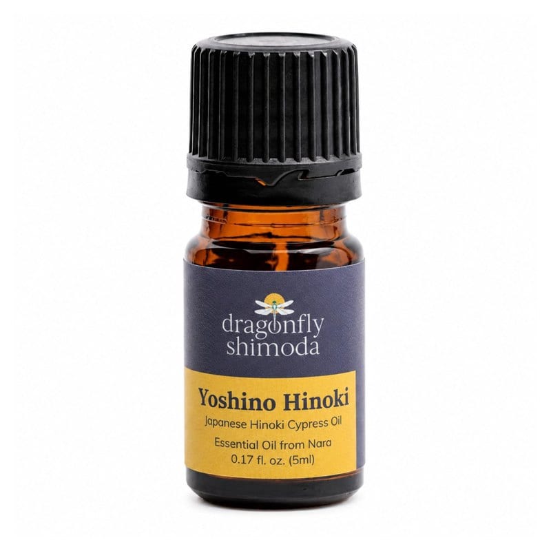 A small amber bottle of Yoshino hinoki essential oil with a purple label